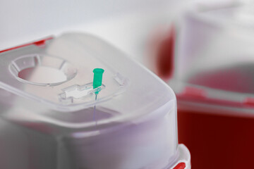 Stuck medical needle in biohazard sharps disposal container