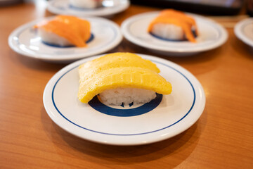 Tamago nigiri sushi or egg sushi on a saucer