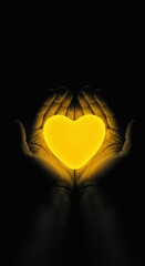 Hands holding a glowing yellow heart on a dark background. Love and care concept.