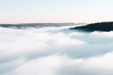 Fototapeta premium Mountain Peak Above Clouds: A serene panorama unfolds as dense fog blankets the valleys, revealing the peaks of mountains, creating an ethereal vista of natural beauty.