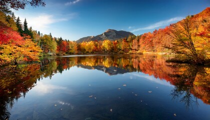 Fototapeta premium A Photography Of A Peaceful Wilderness Lake Surrounded By Autumn Foliage With Vibrant Shades Of Red And Gold Reflecting On The Tranquil Water S Surface A True Seasonal G
