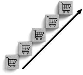 Concrete cubes with shopping cart icons arranged in ascending steps, bold arrow indicating upward...