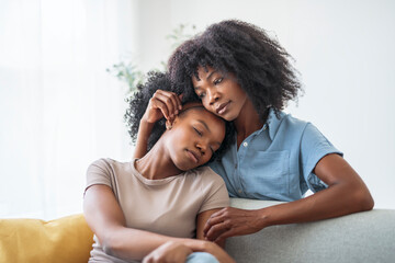 Obraz premium Affectionate mother and daughter sitting on sofa at home