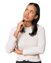 Young Filipina woman looking sideways with doubtful and skeptical expression.