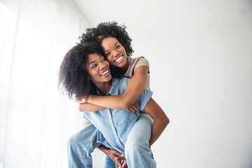 Obraz premium Affectionate mother and daughter portrait close to a white wall