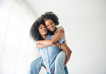 Obraz premium Affectionate mother and daughter portrait close to a white wall