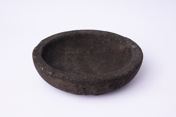 A simple, round stone mortar (cobek) made from dark grey volcanic rock, used for grinding spices and chili. The bowl is isolated on a clean white background.