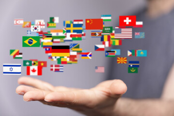 Person holding many flags, representing international communication and global reach.