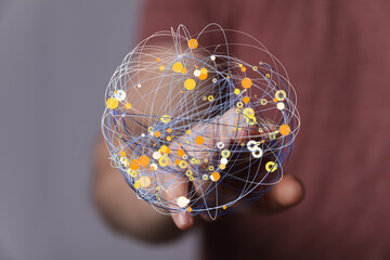 Hand holding a digital sphere, showcasing interconnected data points and global network. Abstract technology concept.