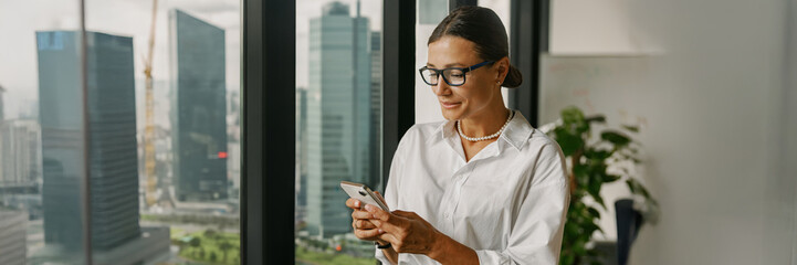 A Business Professional uses a Smartphone in a Modern Office to enhance productivity