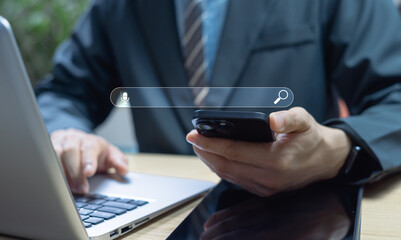 Businessman using AI search engine on smartphone and laptop, representing digital interface, voice query, intelligent search technology, and online information discovery for smart business solutions.