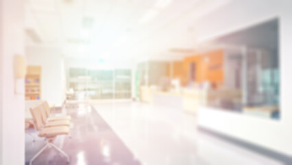 Blur abstract background of corridor in clean hospital. Blurry view of aisle in office with light floor. Defocus walkway in white light building hall with patient registration at reception desk.