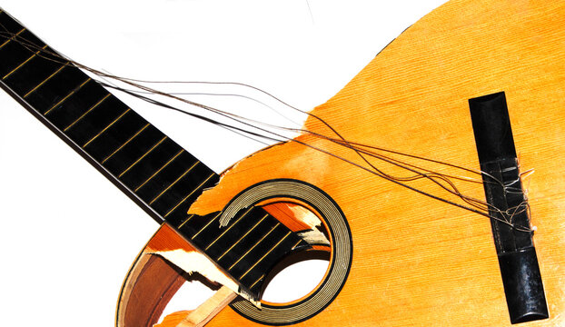 A broken smashed acousitic guitar music instrument on white background