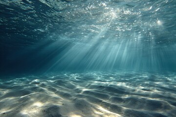 Underwater view of light rays shining through the water, creating patterns on the ocean floor.