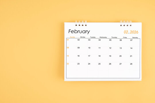 February 2026 desk calendar on yellow color background, position with copy space.