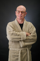 Closeup portrait of a serene aged and balded man in bathrobe