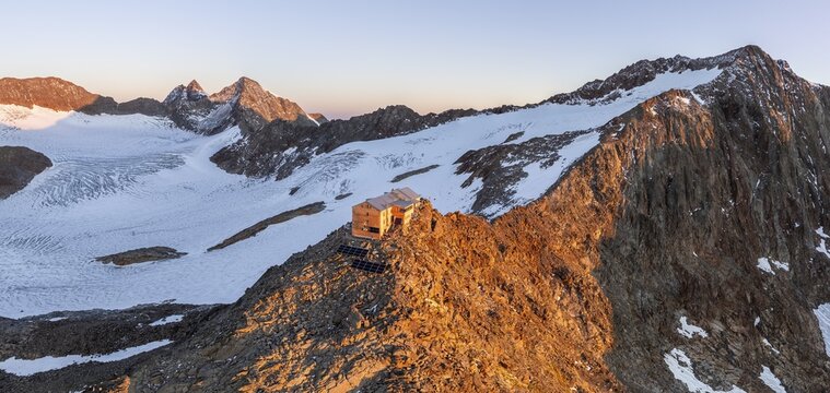 Atmospheric sunrise in a picturesque mountain landscape, alpenglow, aerial view, mountain hut Becherhaus at the summit Becher and glacier &Uuml;beltalferner, Stubai Alps, South Tyrol, Italy