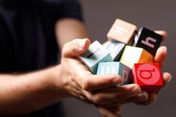 Close-up of hands gently holding colorful wooden alphabet blocks.  Perfect for education, learning, childhood, and literacy concepts.