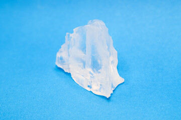 Fototapeta premium Large piece of crystal table salt on bright colored background, close-up.