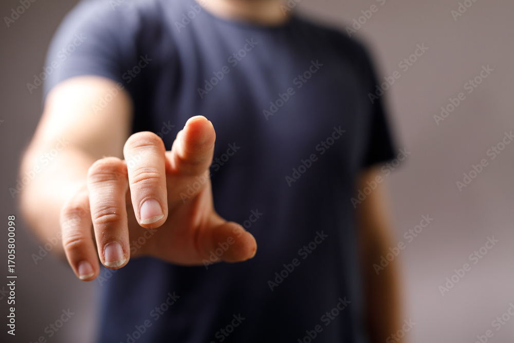 Poster Close-up of a man's hand reaching towards the viewer, index finger extended.  Perfect for concepts of connection, interaction, and technology.
