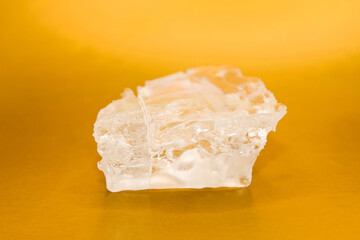 Large piece crystal table salt on bright colored background, close-up.