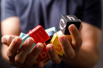 Close-up of child's hands holding colorful alphabet blocks. Perfect for educational, childhood, and learning concepts.