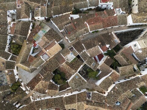 Fototapeta Streets and rooftops in the White Village of Castillo de Castellar which is located inside a Moorish castle. Aerial view. Drone shot. Cádiz province, Andalusia, Spain