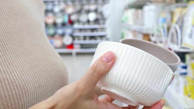 View of woman hands in a kitchenware sales department choosing items for kitchen, perfect for everyday use in a home environment.