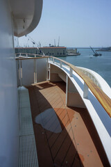 Obraz premium Outdoor sun pool promenade deck with chairs or sun loungers with table on balcony or terrace or patio of luxury cruiseship cruise ship liner cabin suite with amazing oceanview
