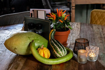 Autumn vegetables pumpkin and squash on a dining table in a rustic restaurant, selective focus. Food and decorations for Halloween celebrations.