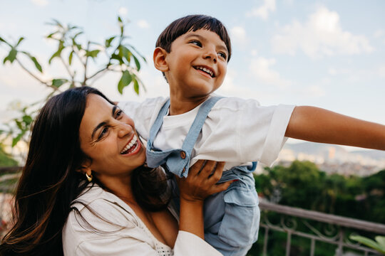 Mother and son enjoying playful moment together outdoors on a sunny day