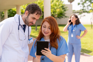 Medical professionals analyzing patient information on digital tablet, supporting collaborative healthcare diagnostic process