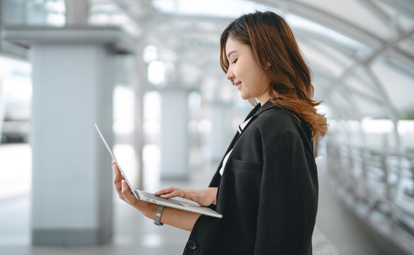 Asian business woman using laptop device remote work with fast wireless internet and ai modern technology - Powered by Adobe