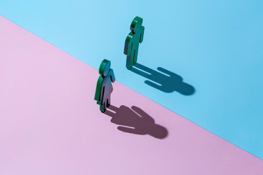 One male and one female figures stand on a surface divided into two halves. Gender differences, social division, gender equality concept. - Powered by Adobe