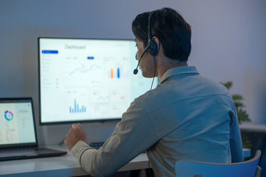 Sales executive in a corporate call center, using wireless technology and a headset to assist clients with real estate and marketing with return of investment needs.