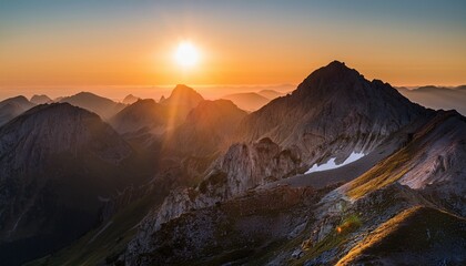 Naklejka premium A Mountain Range With A Sun Setting Behind It