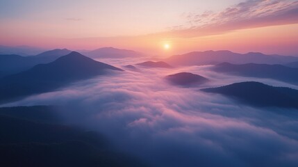 Majestic sunrise over rolling mountain peaks shrouded in soft pink and purple clouds creating a tranquil and awe-inspiring natural landscape scene with vibrant sky colors
