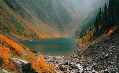 Serene mountain lake embraced by steep slopes adorned in autumnal hues under a hazy sky, creating a picturesque and tranquil natural vista