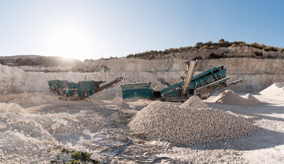 Stone crusher machines working in a quarry extracting gravel and sand