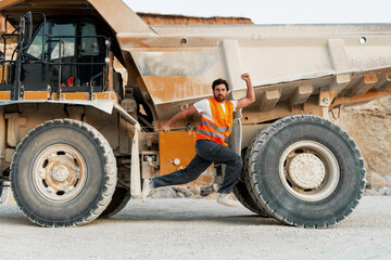 Construction worker jumping next to a dumper truck in a quarry © Maria Vitkovska