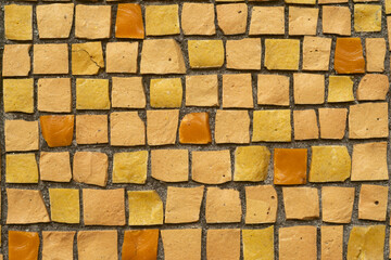 Smalt mosaic with square tiles in yellow and orange shades.