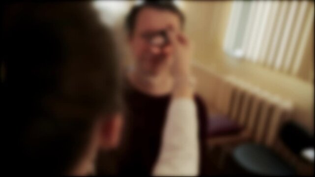 Female ophthalmologist doctor examines the fundus of a male patient, blurred, background. Copy space for text, clarity of vision