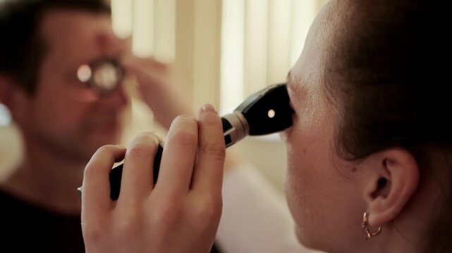 Female ophthalmologist doctor examines the fundus of a male patient, background. Clarity of vision, ophthalmological clinic