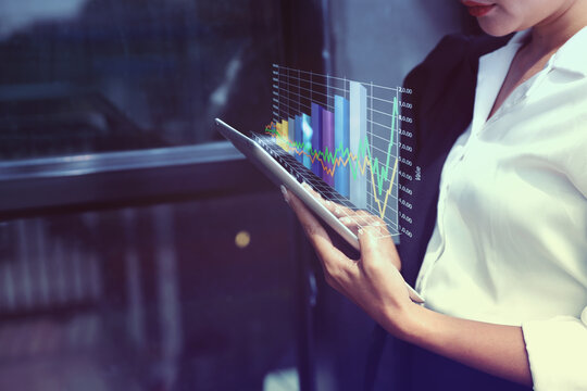 Business Woman Analyzing Financial Data on Tablet. Financial Technology (FinTech) in Use.