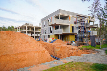 Construction of a three-storey modern house. Residential Buildings of Modern Architecture. Urban villa construction in forest. Condo building in eco-friendly environment. Apartments construction.