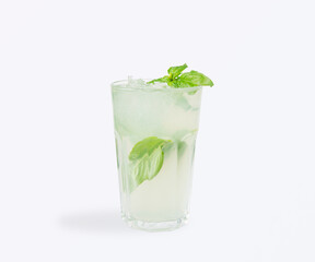 Cold basil lemonade with fresh basil leaves and ice cubes served in a highball glass, light and healthy summer refreshment, perfect for cafe, bar or restaurant menu, isolated on white background