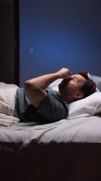 vertical video A man takes off his glasses before going to bed and rubs his tired eyes