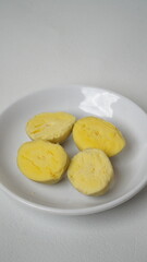 Peeled boiled eggs served on a white plate with a white background