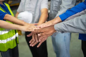 Team collaboration in manufacturing facility work environment hands joining industrial setting unity concept