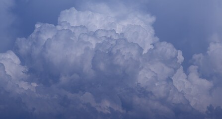 Fluffy cumulus clouds in a serene blue sky.